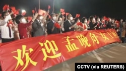 2021年9月25日，在廣東深圳寶安國際機場打著橫幅歡迎孟晚舟回國的人群。（路透社照片）