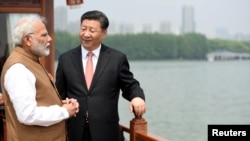 India's Prime Minister Narendra Modi speaks with Chinese President Xi Jinping as they take a boat ride on the East Lake in Wuhan, China, April 28, 2018. 