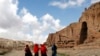 Perempuan Afghanistan berjalan di depan ceruk yang pernah terdapat patung Buddha raksasa, di Provinsi Bamiyan 21 April 2009. (Foto: REUTERS/Omar Sobhani)