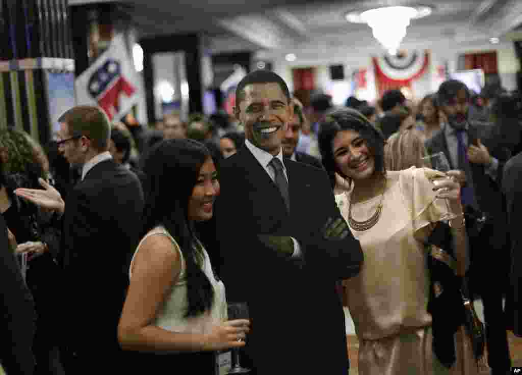 People pose with a picture of President Barack Obama during the Election Night Party 2012 following the U.S. Presidential Election, at the Intercontinental Hotel in Madrid, Spain.