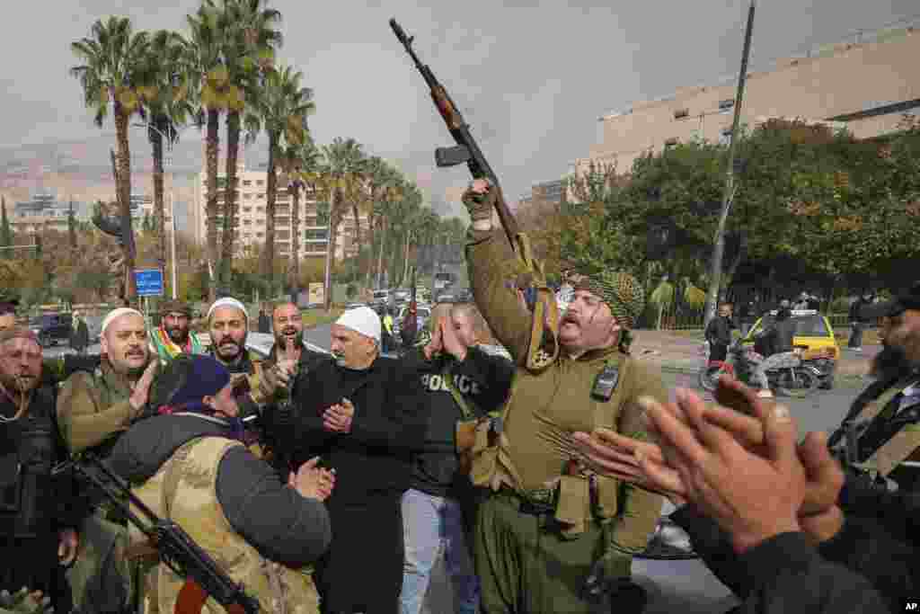 Opposition fighters celebrate the take over of the city by the insurgents in Damascus, Dec. 8, 2024.