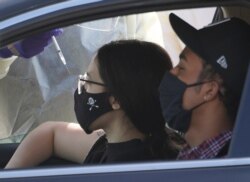 People are vaccinated while sitting inside their vehicles at a mass COVID-19 vaccination site outside The Forum in Inglewood, California, January 19, 2021.