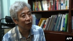 FILE - Former professor Wenguang Sun speaks in his home in Jinan, east China's Shandong province, Aug. 28, 2013.