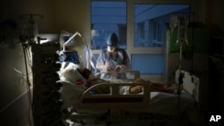 Medicinska sestra brine o pacijentu obolelom od kovida 19 prikačenom na respirator u intenzivnoj nezi u bolnici u Marseju, 31. decembra 2021. (Foto: AP/Daniel Cole