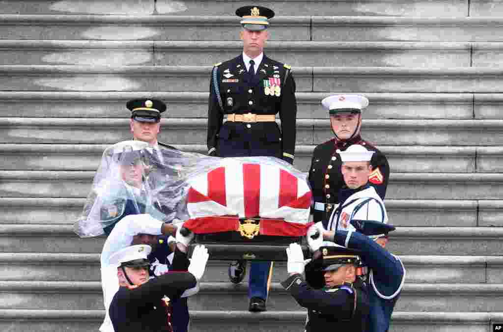El ataúd del senador John McCain, republicano de Arizona, es llevado escaleras abajo en el Capitolio de los Estados Unidos en Washington, el 1 de septiembre de 2018, camino a la Catedral Nacional de Washington para un servicio conmemorativo. 