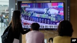 People watch a TV screen showing a file image of a North Korean missile in a military parade during a news program at the Seoul Railway Station in Seoul, South Korea, Aug. 30, 2021.