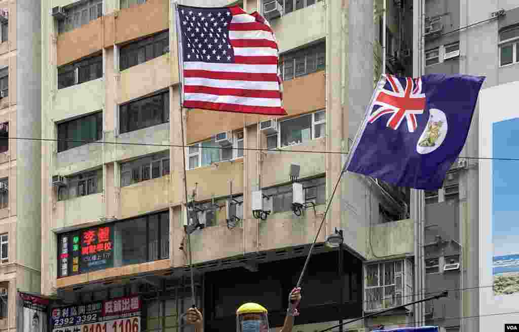 參與5-24港島反惡法遊行的示威者高舉美國旗及港英殖民時期的香港旗,在港版中國國家安全法實施後,可能觸犯相關法例。(美國之音湯惠芸拍攝)