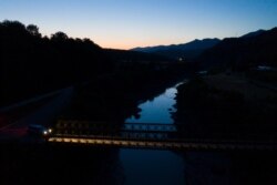 FILE - The sky is reflected in the Vjosa River after sunset near the village of Badelonje, Albania, June 30, 2019. Rivers are a crucial part of the global water cycle. They act like nature's arteries.