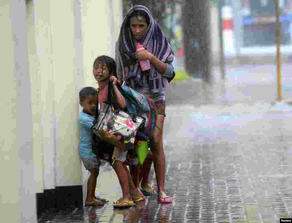 Seorang ibu bersama dua anaknya berlindung ketika topan Haiyan menghantam Kota Cebu, Filipina tengah.