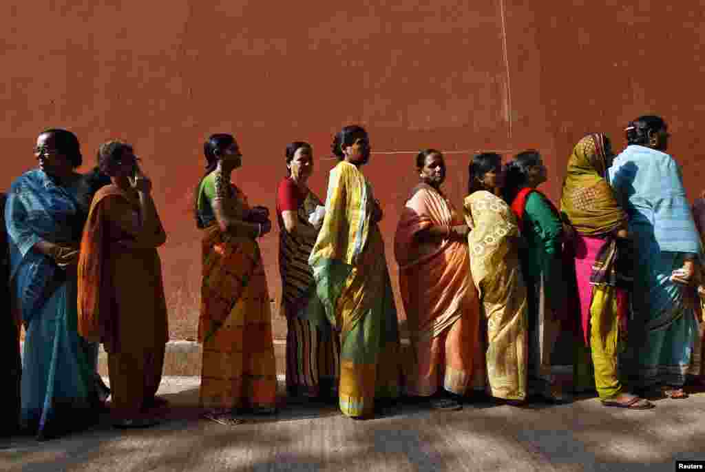 Women line up to cast their votes outside a polling station during the seventh phase of India's general election at Howrah district in the eastern Indian state of West Bengal, April 30, 2014.