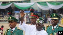 Rais wa Nigeria Bola Ahmed Tinubu, akiwakagua walinzi wa heshima baada ya kula kiapo katika sherehe mjini Abuja, Nigeria, Mei 29, 2023.
