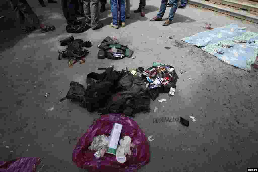 People stand near belongings of separatists killed in a fight with pro-Ukrainian forces outside a morgue in Donetsk, Ukraine, May 27, 2014.