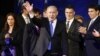 Israel's Prime Minister Benjamin Netanyahu waves to supporters as he stands with his party members at the Likud-Yisrael Beitenu headquarters in Tel Aviv January 23, 2013.