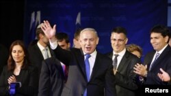 PM Israel Benjamin Netanyahu melambaikan tangan ke arah para pendukungnya didampingi anggota partainya di kantor pusat partai Likuddi Tel Aviv January 23, 2013. (REUTERS/Nir Elias) 