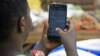 Une femme passe en revue son compte WhatsApp sur son téléphone, à Kampala, le 5 juillet 2018.