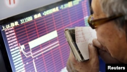 An investor looks at a screen showing stock information, after the new circuit breaker mechanism suspended today's stocks trading, in Shanghai, China, Jan. 7, 2016. (REUTERS/China Daily)