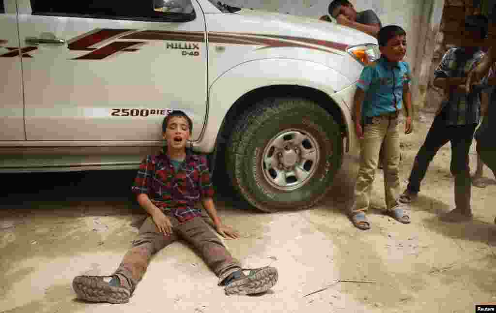 The son (L) of one of the Palestinian members of Tayseer Al-Batsh's family, who hospital officials said were killed in an Israeli air strike, mourns during their funeral in Gaza City July 13, 2014.