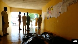 Des membres de la famille attendent de réclamer les corps des victimes d'un attentat-suicide dans un hôpital de Konduga, près de Maiduguri, au Nigéria, le 16 août 2017.