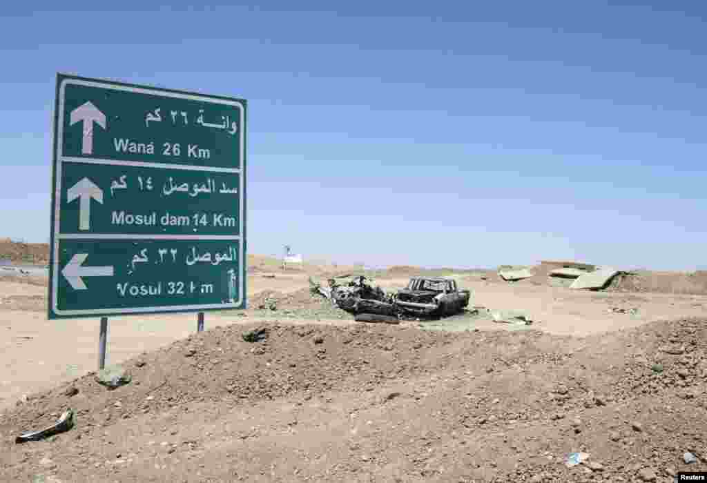 The wreckage of a car belonging to Islamic State militants lies along a road after it was destroyed by a U.S. air strike near the entrance to Mosul Dam, Aug. 21, 2014.
