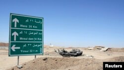 Wreckage of a car belonging to Islamic State militants lies along a road after it was targeted by a U.S. air strike at the entrance to the Mosul Dam, northern Iraq, Aug. 21, 2014.