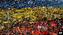 People light the flashes of their mobile phones in the colors of Romania's flag during an anti-government protest in Bucharest, Romania, Feb. 12, 2017.