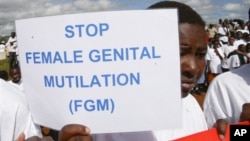 Anak perempuan dari suku Masai membawa poster dalam protes menentang Mutilasi Kelamin Perempuan di Kilgoris, Kenya. 