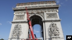 Cranes operate at the Arc de Triomphe in Paris, Aug.24, 2021. The L'Arc de Triomphe, Wrapped project by late artists Christo and Jeanne-Claude will be on view from Sept.18-Oct. 3, 2021.