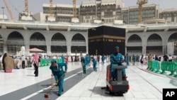 Des ouvriers nettoient la Grande Mosquée, lors du pèlerinage mineur, connu sous le nom de Oumrah, dans la ville sainte musulmane de La Mecque, en Arabie Saoudite, le lundi 2 mars 2020. (AP Photo/Amr Nabil)