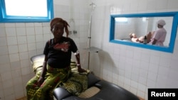 FILE - A pregnant woman waits while another goes into labor at a general hospital.