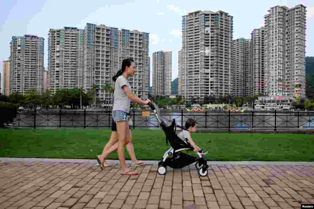 2018年6月27日，妇女推着小孩儿走过中国中山市的住宅开发项目。