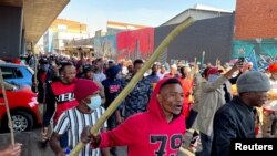 Stick-wielding protesters march through the streets as violence following the jailing of former South African President Jacob Zuma spread to the country's main economic hub in Johannesburg, South Africa, July 11, 2021. REUTERS/ Siphiwe Sibeko