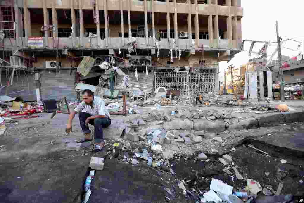 An Iraqi man inspects the site of a car bomb attack in central Baghdad's busy commercial Karradah neighborhood, Aug. 13, 2014.