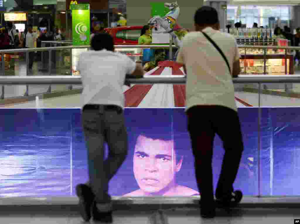 Filipino fans look at the memorabilia of the Oct. 1, 1975 "Thrilla in Manila" World Heavyweight boxing fight between Muhammad Ali and Joe Frazier at the launch of an exhibit at The Ali Mall in suburban Quezon city northeast of Manila, Philippines Friday,