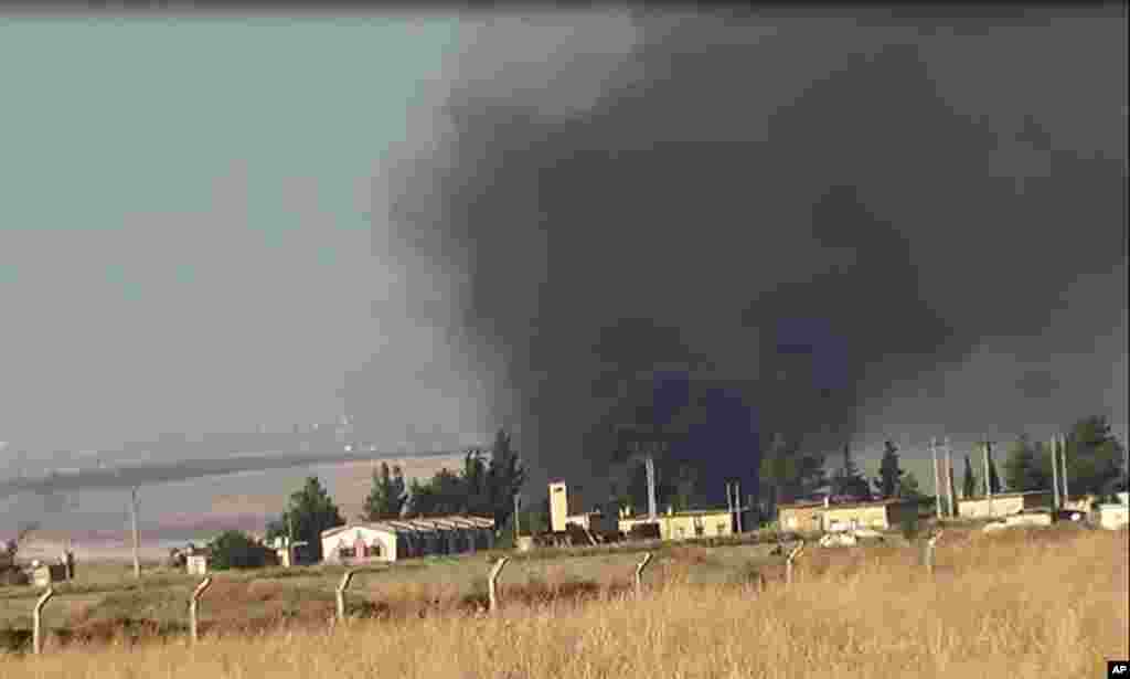 This citizen journalism image provided by ENN shows black smoke rising from what rebels say is a helicopter that was shot down at Abu Dhour military airbase, Idlib, Syria, May 17, 2013.