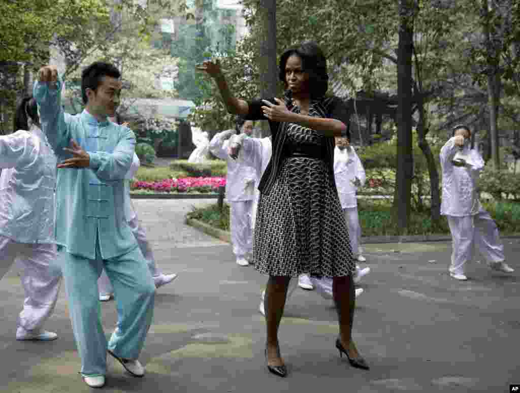 U.S. first lady Michelle Obama practices tai chi with students at Chengdu No.7 High School in Chengdu in southwest China's Sichuan province, March 25, 2014.