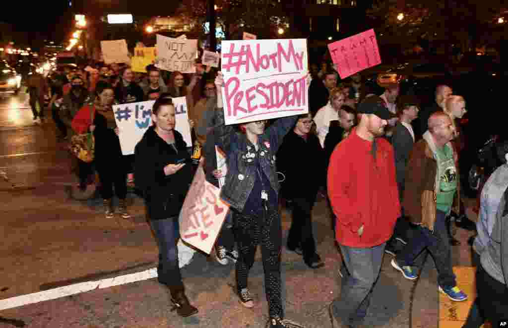 Protesters holds up signs in opposition of Donald Trump's presidential election victory as they march from Jefferson Square Park in Louisville, Kentucky, Nov. 10, 2016.