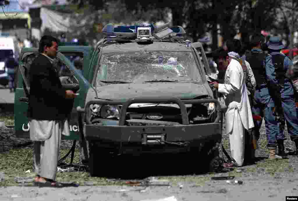Afghan security forces personnel investigate the site of an explosion in Kabul, June 18, 2013.