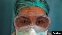 Kacamata seorang perawat, Dilara Fahrioglu, tertutup uap setelah merawat pasien yang menderita Covid-19 di unit perawatan intensif Rumah Sakit Internasional Medicana di Istanbul, Turki, 14 April 2020. (Foto: Reuters)
