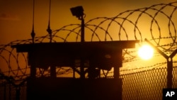 FILE - The sun rises above Camp Delta at Guantanamo Bay Naval Base, Cuba.