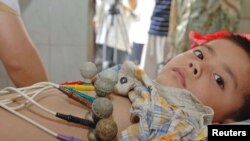 FILE - Five-year-old child receives Hepatitis A vaccine at the People's Hospital of Sixian county, China's Anhui province.