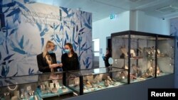 Personal de la joyería Sothesby's, usan tapabocas para atender a los clientes que realizarán una vista previa a las joyas antes de iniciar una subasta digital, en Ginebra, Suiza.