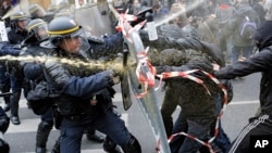 Policías antidisturbios luchan con manifestantes que piden un acuerdo para detener el cambio climático, en la Plaza de la República en París, un día antes de la Cumbre del Clima de la ONU.