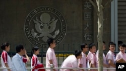 Sejumlah pelajar China menunggu di luar Kedutaan Besar AS untuk wawancara permohonan visa, di Beijing, China, Mei 2012. (Foto: Alexander F. Yuan/AP Photo)