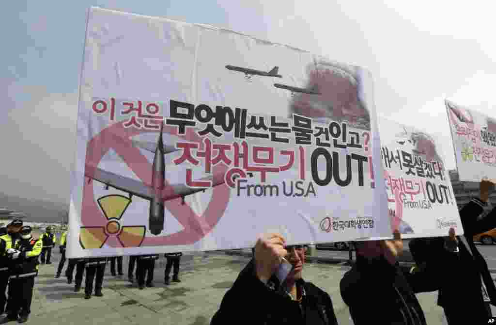Anti-war protesters raise signs during a rally denouncing the joint military drills between the South Korea and the United States near the U.S. Embassy in Seoul, South Korea, April 3, 2013.