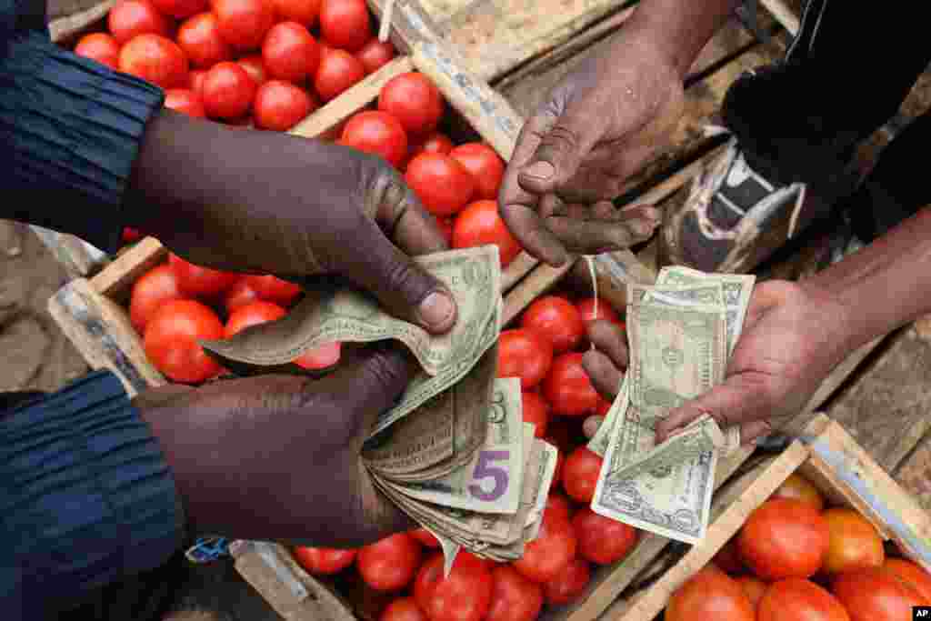 ZIMBABWE: A high percentage of fresh vegetables are damaged in packaging for overland transit. A vendor sells tomatoes at Harare's largest produce market, Mbare Musika on Friday, Oct. 11, 2013. 