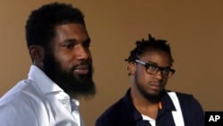 In this Wednesday, April 18, 2018 photo, Rashon Nelson, left, and Donte Robinson, right, listen to a reporter's question during an interview with The Associated Press in Philadelphia. (AP Photo/Jacqueline Larma)