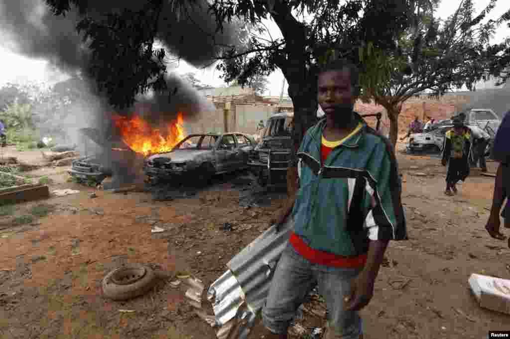 A man takes part in looting a mosque in Fouh district in Bangui, Central African Republic, Dec. 10, 2013.