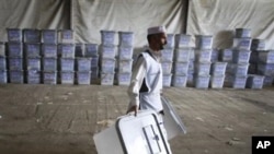 An Afghan election worker carries ballot boxes at the warehouse of Afghanistan's Independent Election Commission in Kabul, Afghanistan, a few days after parliamentary elections on September 18, 2010.