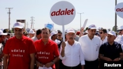Pemimpin partai oposisi utama Partai Republik Turki (KUB) Kemal Kilicdaroglu (C) dan Sekjen Sosialis Internasional Luis Ayala (2 L) berjalan diapit oleh pendukung pada hari ke-14 aksi "Justice March" menentang penahanan anggota parlemen CHP Enis Berberoglu, di Duzce, Turki 28 Juni 2017. (REUTERS/Umit Bektas).