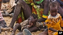 Turkana women and their children wait to receive relief food supplies near the Kakuma Refugee Camp, Turkana District, northwest of Kenya's capital Nairobi, August 8, 2011